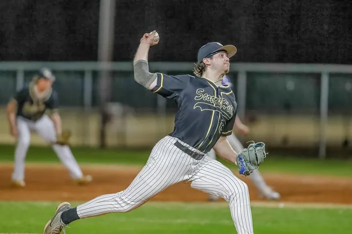 Cy delivering a pitch in a pinstriped uniform