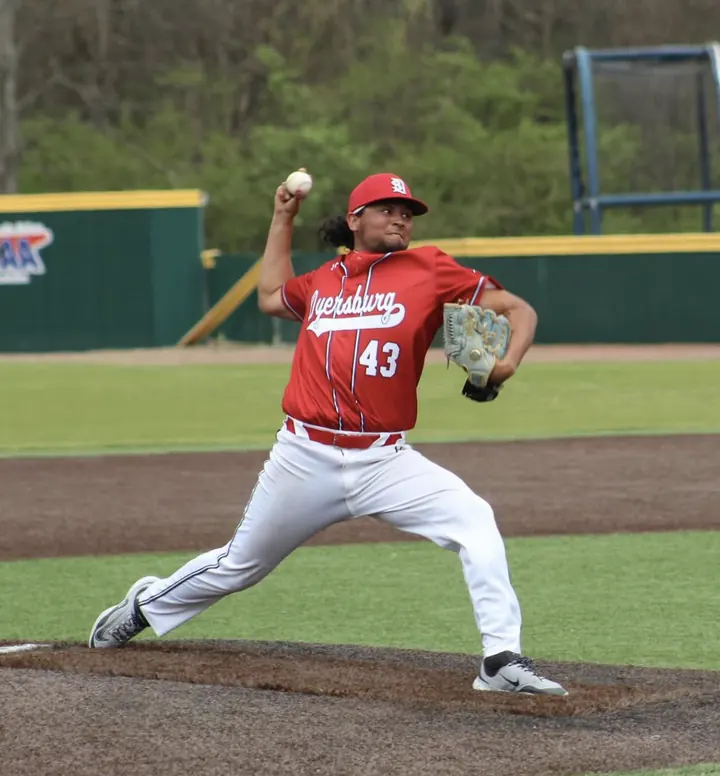 Francisco delivering a pitch in a red jersey