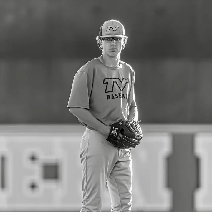 Black and white portrait of Nick holding his glove